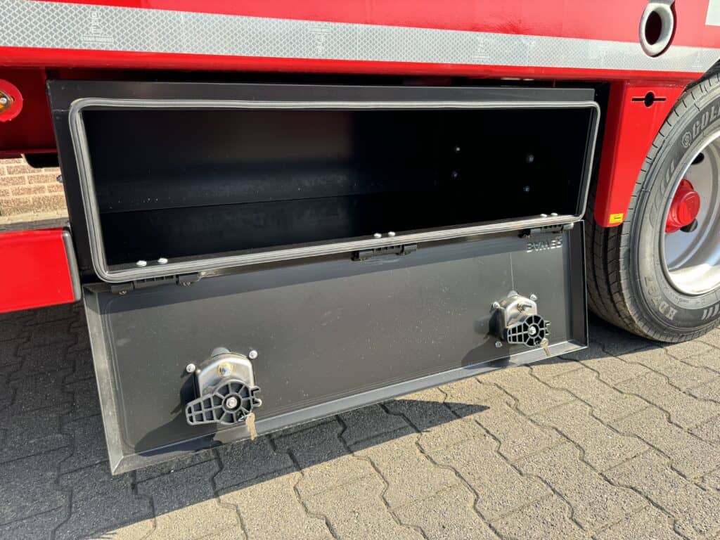 Onderzijnde laadruimte van een professionele vrachtwagen of aanhanger met elektrische aansluitingen.