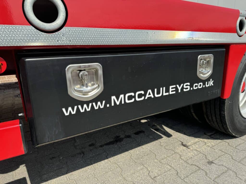 Robuust voertuig met bedrijfsnaam en website voor bouwmaterialen en transport.