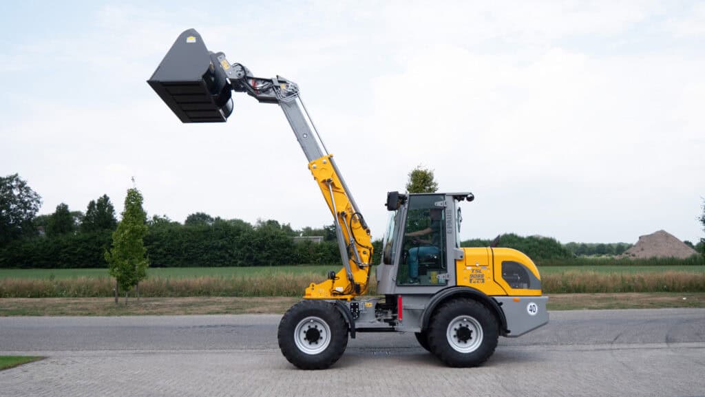 Hoogwerkermachine met hefarm voor bouw- en landwerk, geel en zwart, op straat.