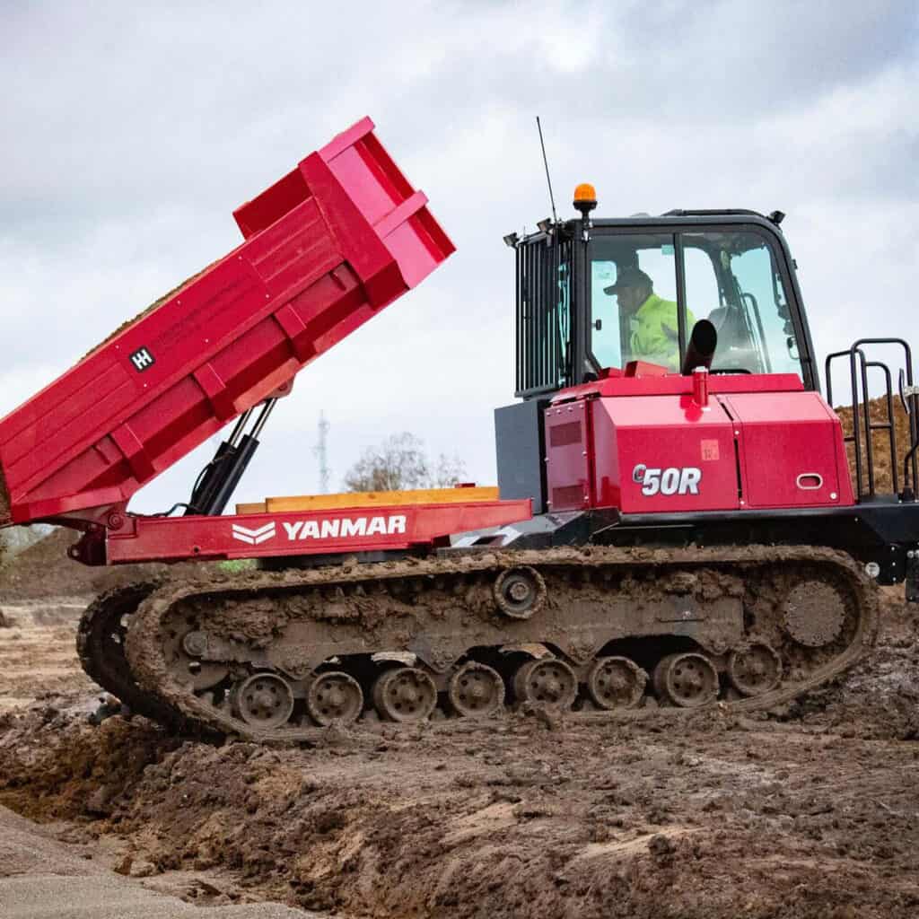 Betonmixer met rupstransportband op bouwplaats, Yanmar machine in actie.