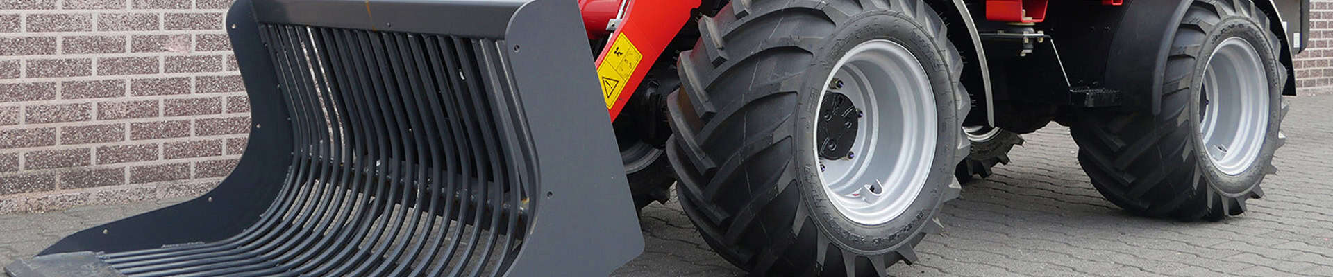 Zeer stevige tractor met brede banden en frontlader, geschikt voor agrarische activiteiten.