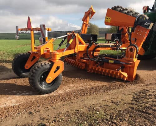 Robuuste landbouwmachine in oranje voor bodembewerking op een akker, ideaal voor professionele boeren.