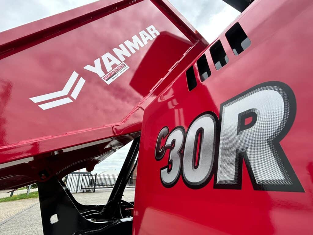 Yanmar hijsysteem met logo en modelnummer op een rode tractor, geschikt voor landbouwtoepassingen.