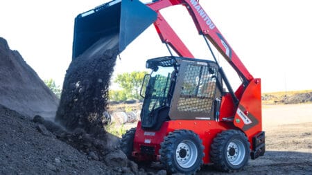 Kleine graafmachine tijdens het werken op een bouwplaats met dynamische omgeving en achtergrond.