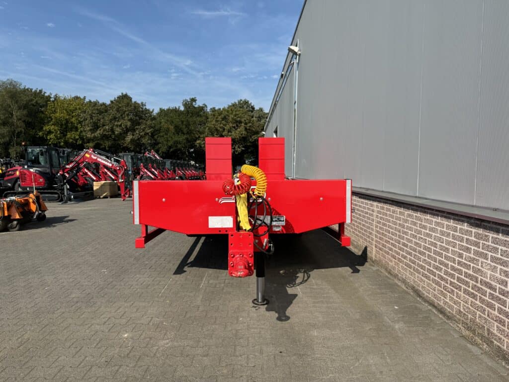 Robuuste rode landbouwwagen met hydraulisch systeem en steunpoot voor professioneel gebruik.