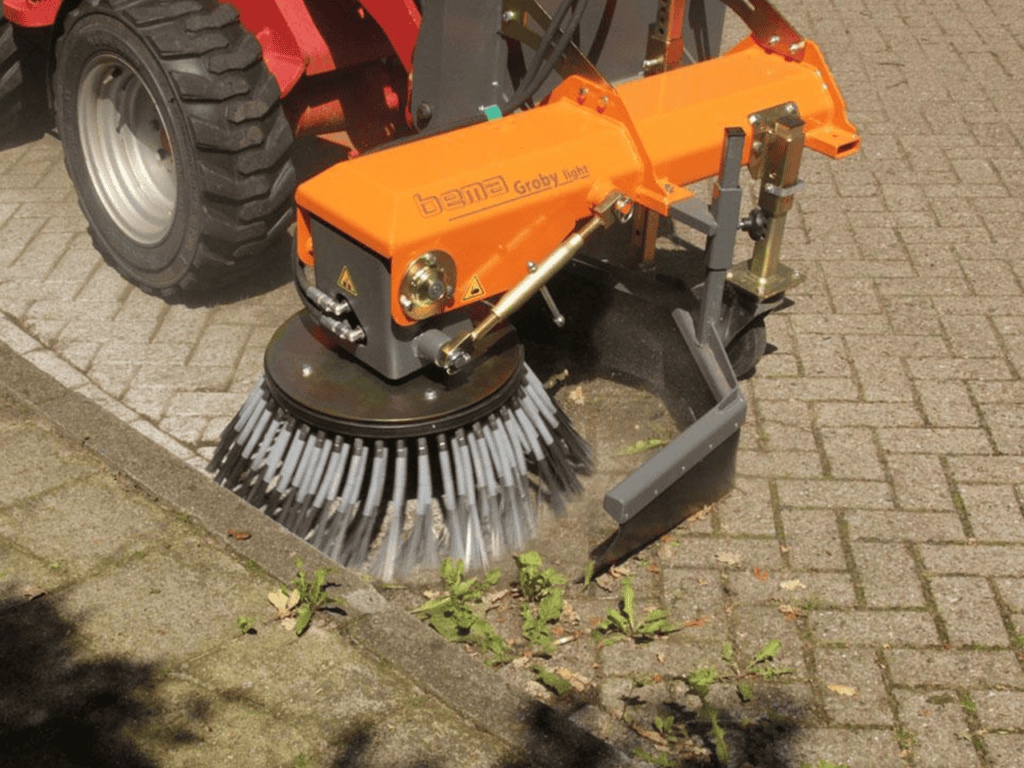 Alt text: Industriële straatborstelmachine voor grond en bestratingreiniging.