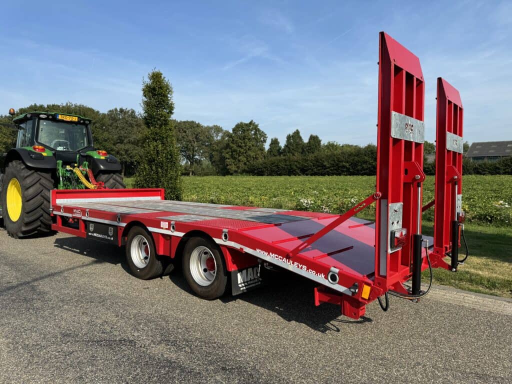Fraaie trucktruck voor vervoer van machines en materiaal, afgebeeld tijdens een zonnige dag op het platteland.