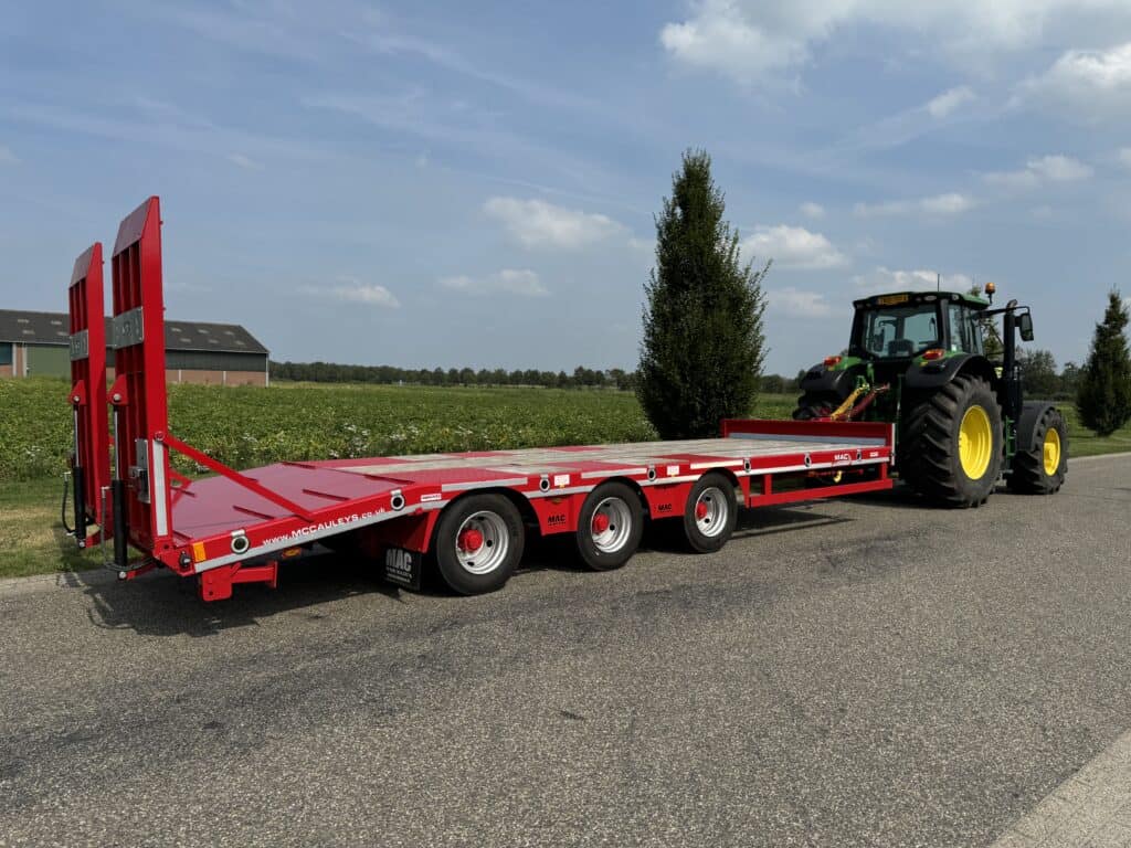 Veetrailer voor zwaar landbouwverkeer met tractor, geschikt voor transport van machines.