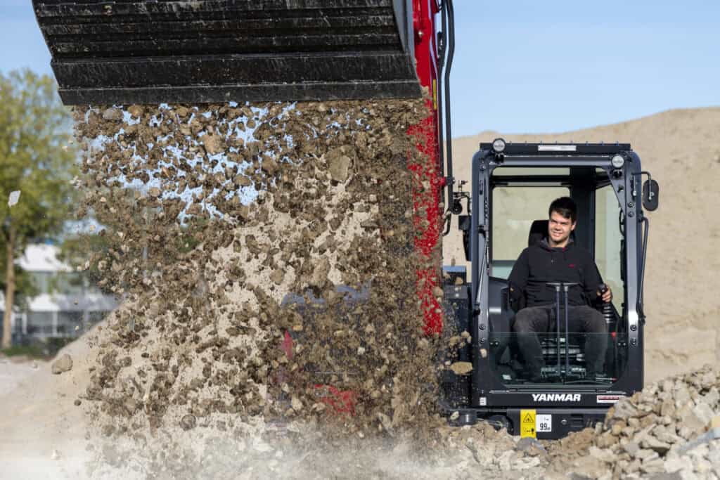 Stilte, jonge man bestuurt minishovel voor grondverzet en bouwwerkzaamheden.