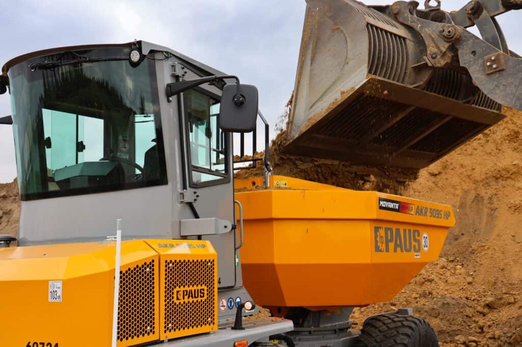 Klein graafmachine met afvalbak op bouwplaats voor milieuvriendelijke afvalverwerking.