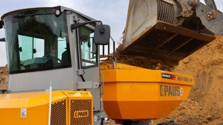 Klein graafmachine met afvalbak op bouwplaats voor milieuvriendelijke afvalverwerking.