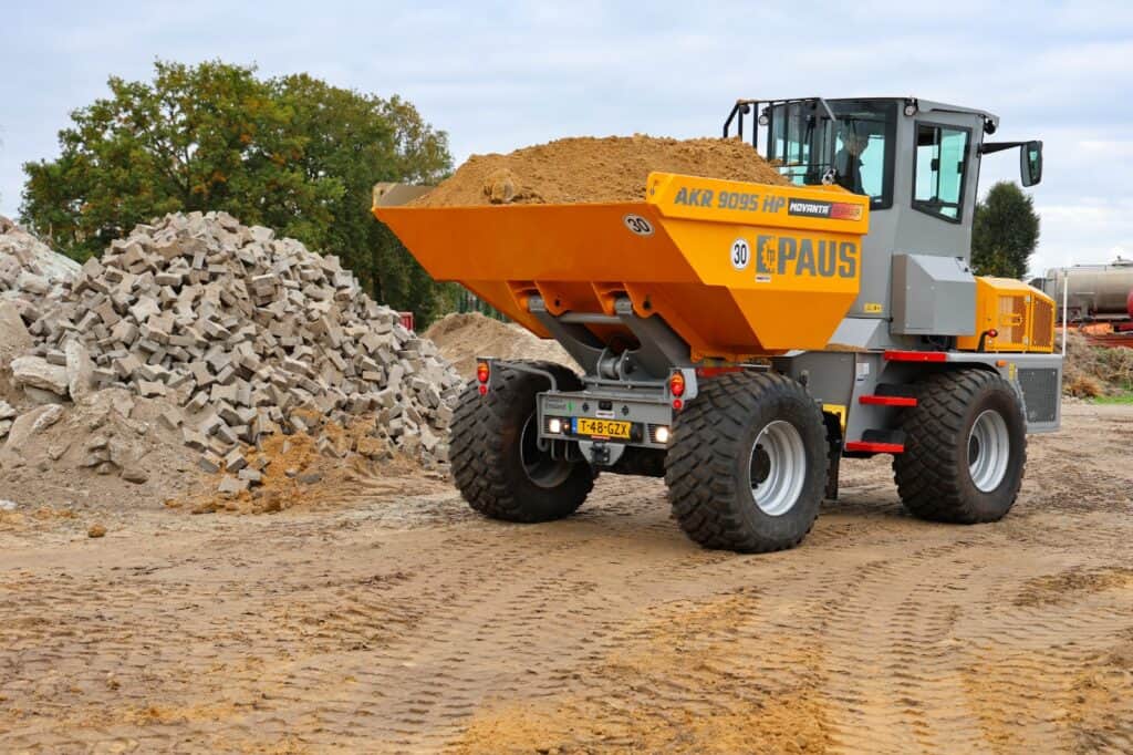 Zand- en grindtransport met verkeersvrij betonblok op bouwplaats.