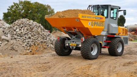 Zand- en grindtransport met verkeersvrij betonblok op bouwplaats.