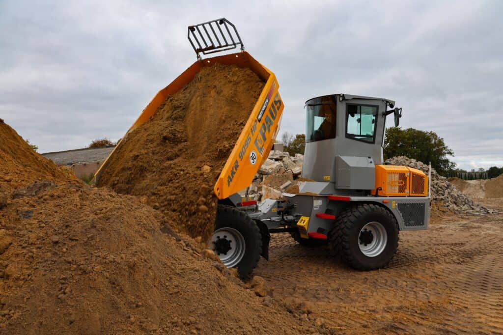 Klepelkuiler in actie bij bouwproject, gespecialiseerd in grondverzet en grondwerkzaamheden.