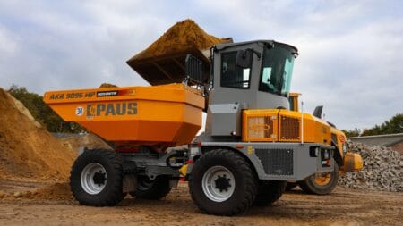 Kleuren geel en grijs, bouwvoertuig met speciekuip op bouwplaats, bouwmachines, bouwwerkzaamheden, bouwbedrijf.