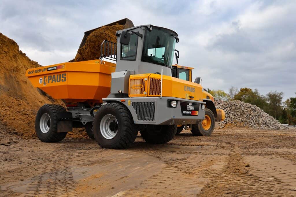 Robuuste betonnen wiellader op een bouwplaats met aarde en gesteente.