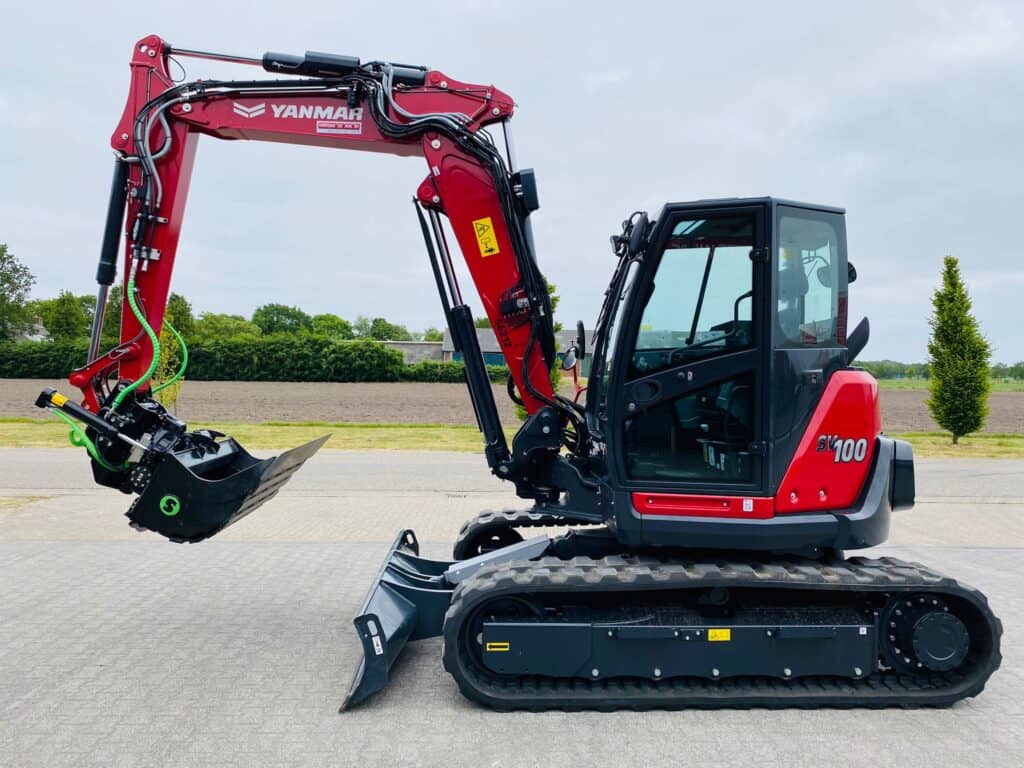 1. Volledig nieuwe Yanmar SV100 minikraan op wegen met grond en landschap op achtergrond.
