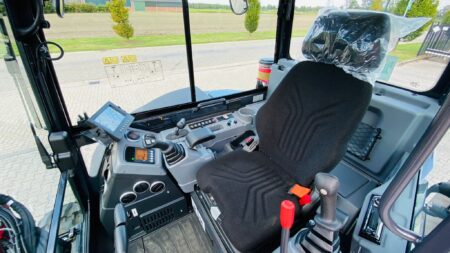 Veilig bestuurbare landbouwmachine cabine met geavanceerd bedieningspaneel en comfortabele stoel.