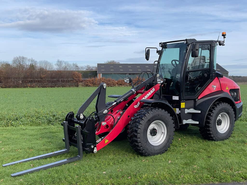 Krachtige MANMAR landbouwtractor met vorkheftruck voor boerderij werkzaamheden.