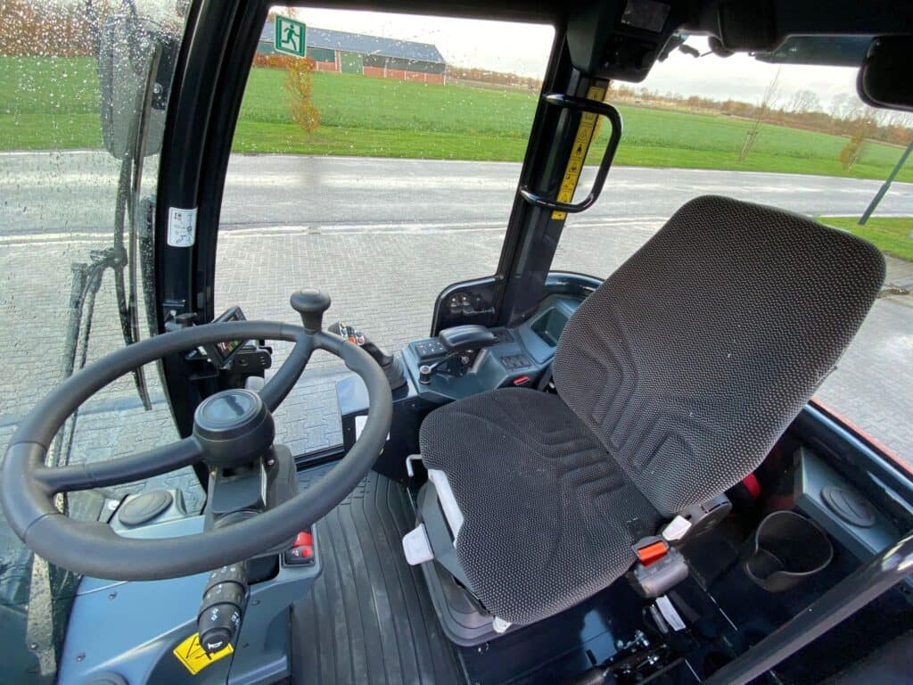 Steuervliegtuig interieur met geavanceerde bedieningselementen en comfortabele stoel, geschikt voor landbouw- en tuinbouwmachines.