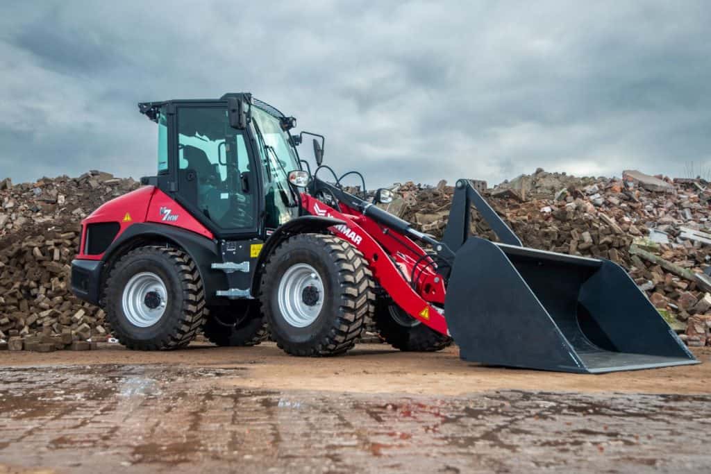 Robuuste rode vorkheftruck op bouwterrein met puin en graafwerk, beschikbaar bij Geert-Jan de Kok B.V.