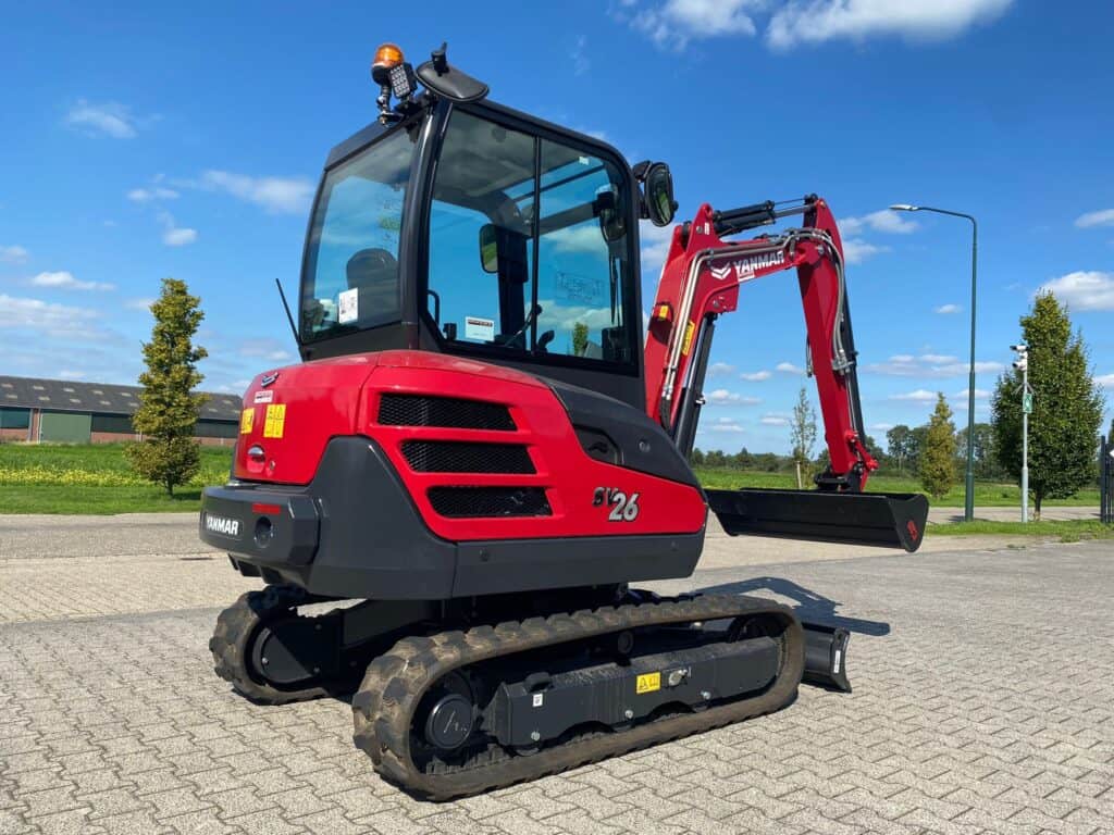 Compacte mini excavator Yanmar SV26 op betonnen oprit, geschikt voor tuin- en bouwprojecten.