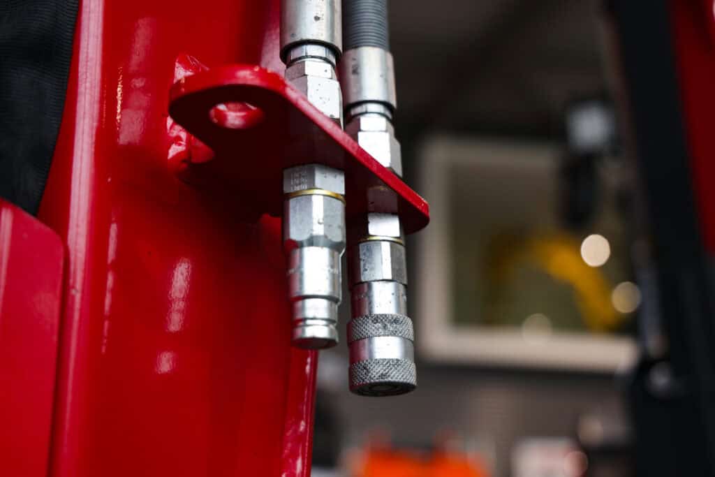 Stalen hydraulische slangen en koppelingen op een machine of voertuig.