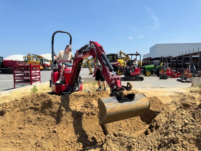 Mini shovel machine werkzaamheden bouwplaats, jonge jongen werkt met mini graafmachine.