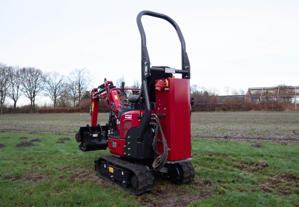 Kleine graafmachine op bouwgrond voor tuin- en landschapsprojecten.