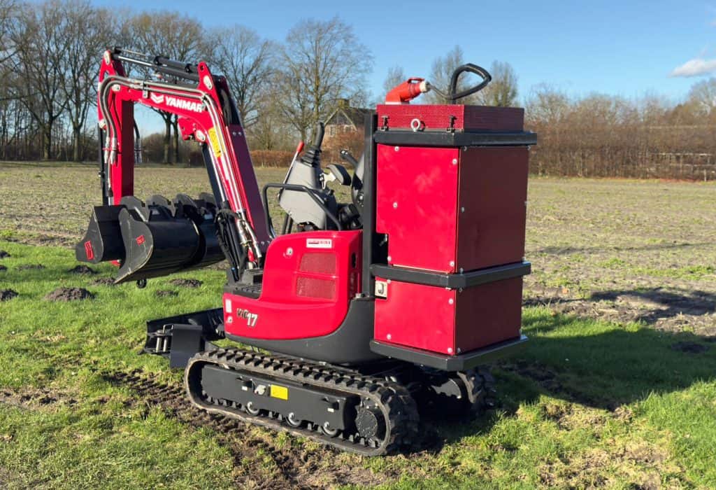 Compacte mini-tractor met graafarm en oprijframe, geschikt voor tuin- en landschapswerk.